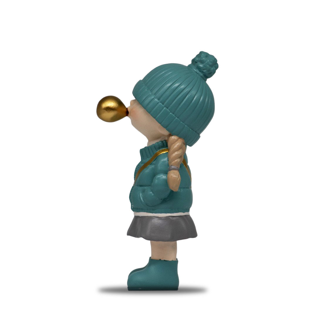 Figura Decorativa de Poliresina Niña con Chicle, Chamarra Turquesa 20 cm